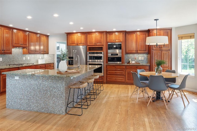 2345 Spotswood Pl, Boulder, CO 80304 - kitchen featuring stainless steel appliances, light wood-type flooring, brown cabinets, recessed lighting, and tasteful backsplash