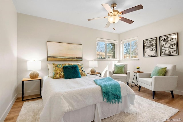 bedroom with a ceiling fan, baseboards, and wood finished floors