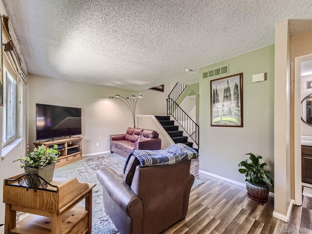 living room with a textured ceiling and hardwood / wood-style floors