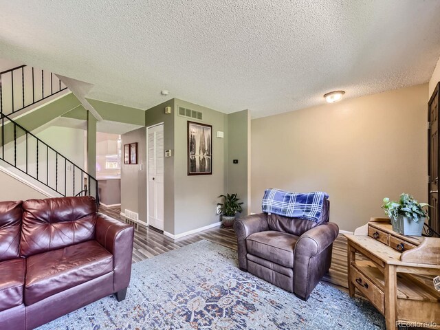 living room featuring a textured ceiling and hardwood / wood-style floors