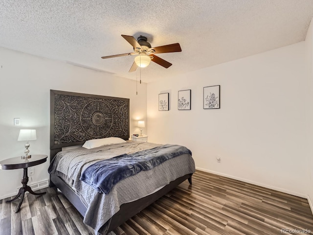 bedroom with ceiling fan, dark hardwood / wood-style flooring, and a textured ceiling