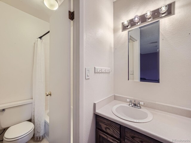 full bathroom with shower / bath combination with curtain, toilet, and vanity