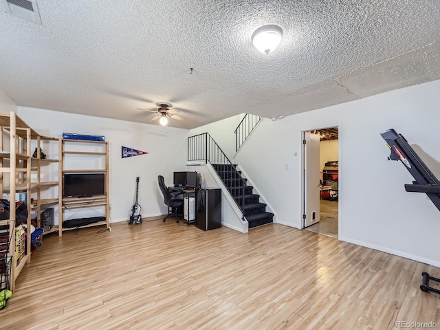 interior space with light wood-type flooring, a textured ceiling, and ceiling fan