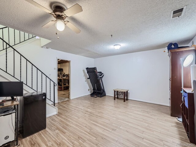 interior space with a textured ceiling, light hardwood / wood-style flooring, and ceiling fan