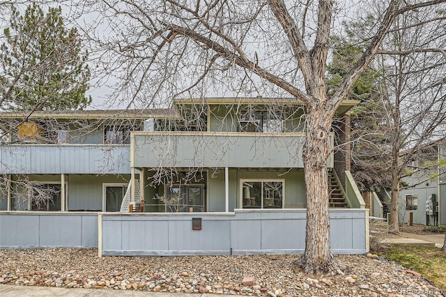 view of front of house featuring stairway and a balcony