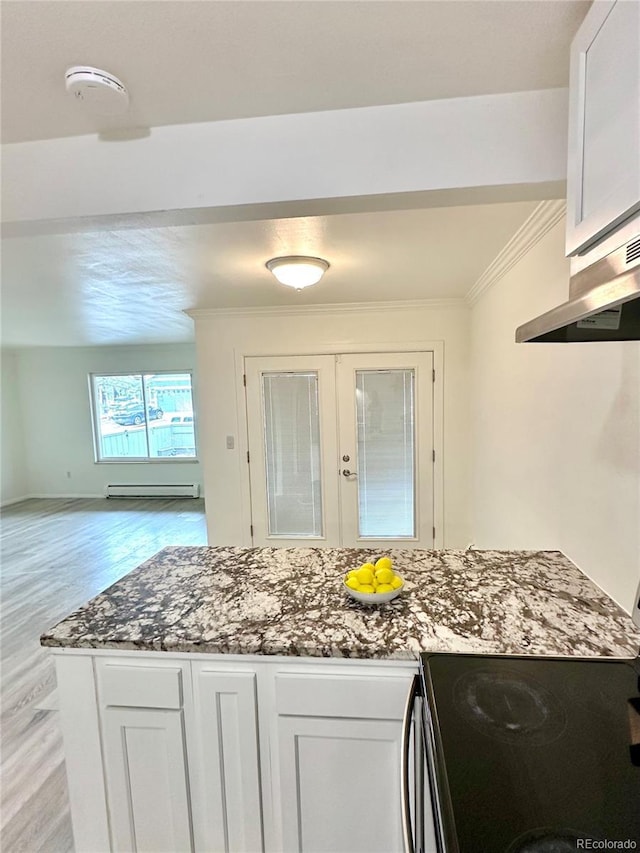 kitchen with dark stone countertops, ornamental molding, light wood-style floors, white cabinetry, and french doors