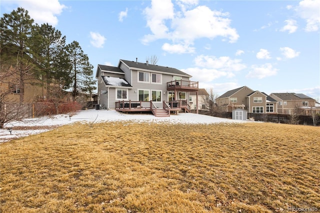 rear view of property with fence, a deck, and a lawn