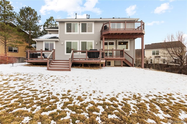 snow covered property with stairs and a wooden deck