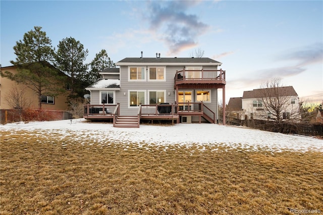 snow covered property with a yard, a deck, and a balcony