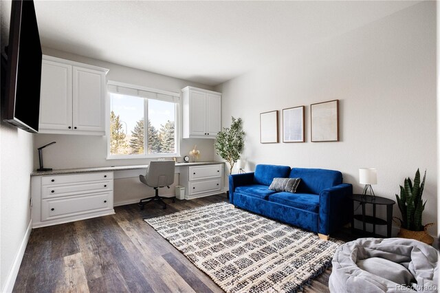 office area featuring dark wood-type flooring, built in study area, and baseboards