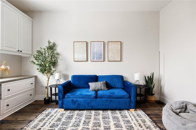 living area with dark wood-type flooring and baseboards