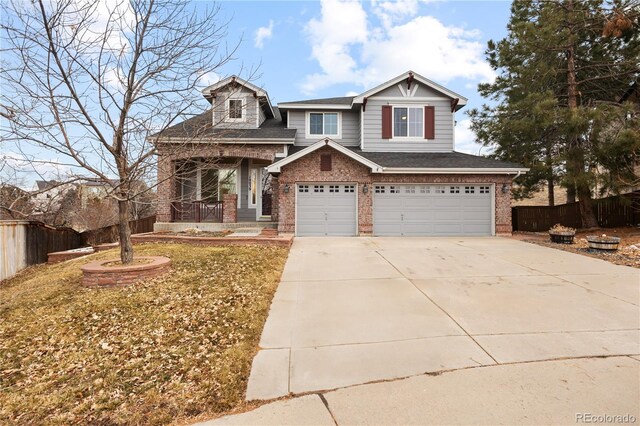 craftsman-style home with a garage, driveway, roof with shingles, fence, and brick siding