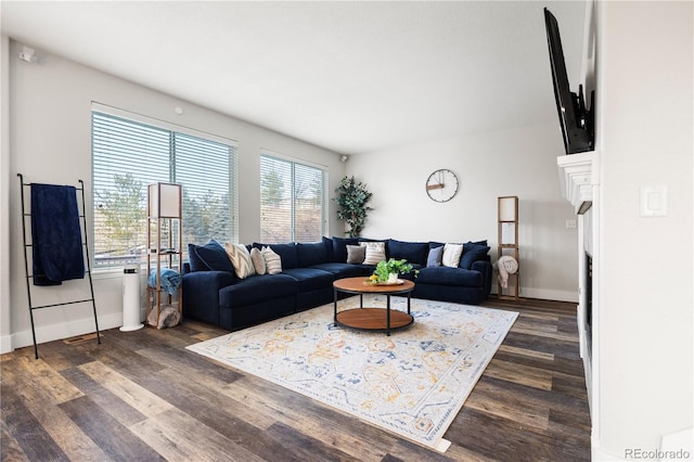 living area featuring baseboards, a fireplace, and dark wood-style flooring