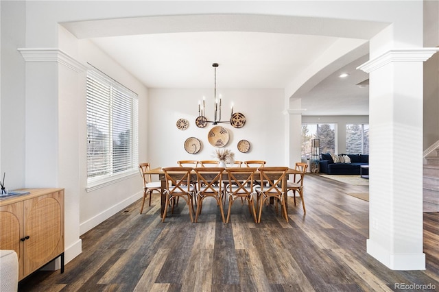 dining space with arched walkways, decorative columns, dark wood-type flooring, and baseboards