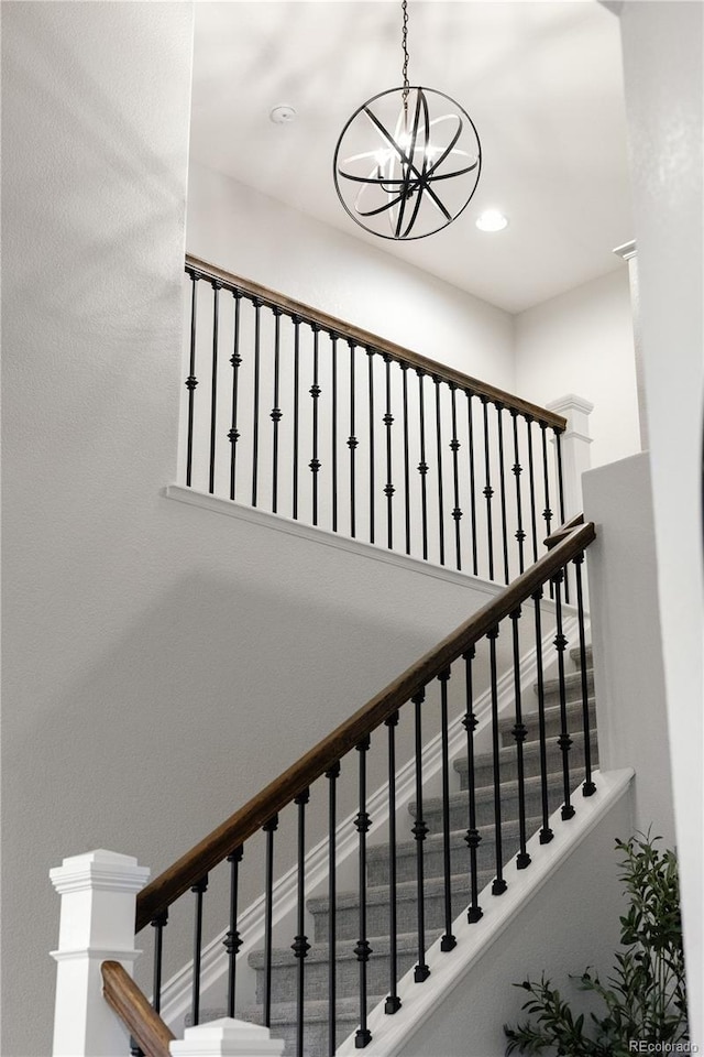 stairs with recessed lighting and a notable chandelier
