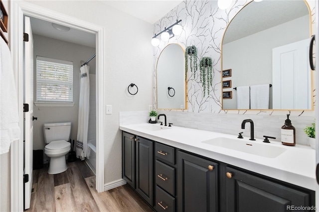 full bathroom with wood finished floors, a sink, double vanity, and toilet