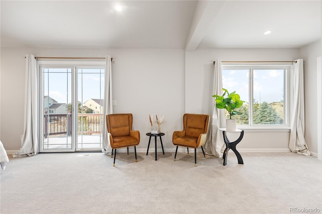 sitting room with baseboards, beamed ceiling, and carpet
