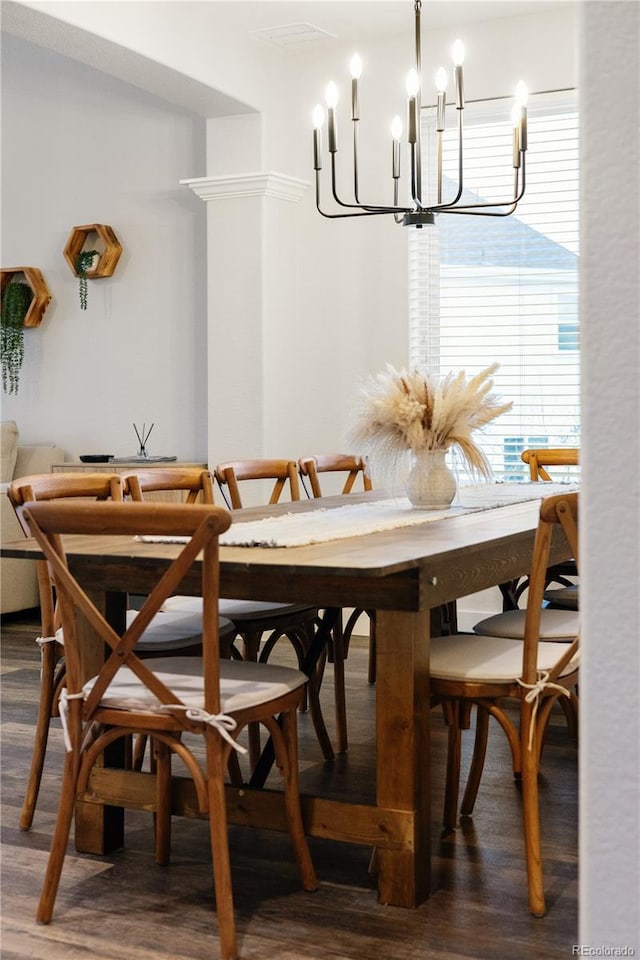 dining room with dark wood finished floors and an inviting chandelier