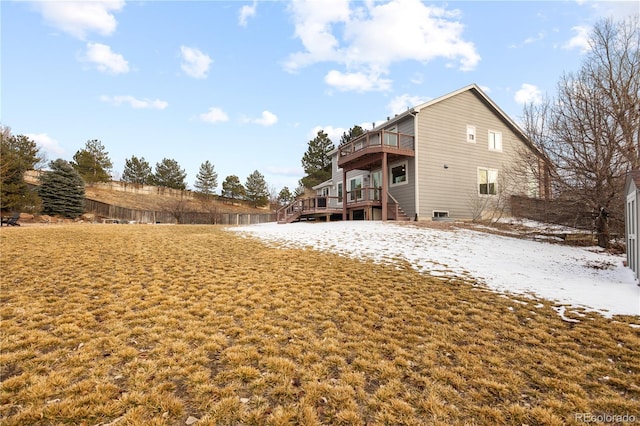 snow covered property with a wooden deck and a balcony
