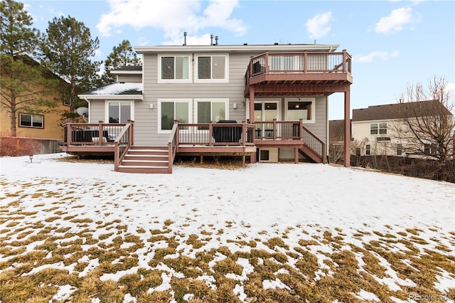 snow covered house featuring a wooden deck