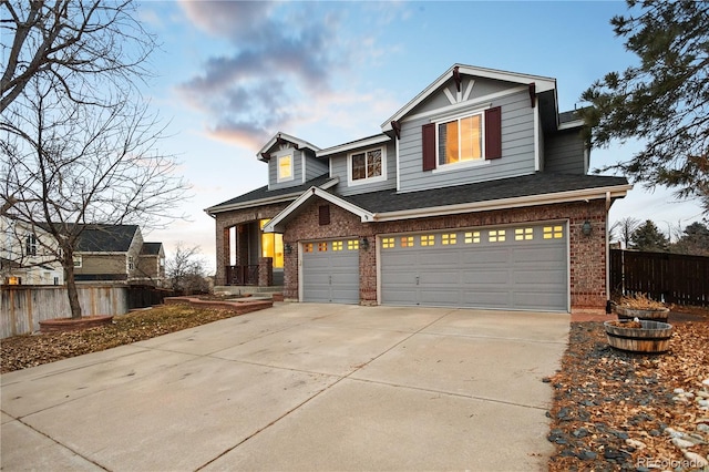 view of front of property with fence, roof with shingles, an attached garage, driveway, and brick siding