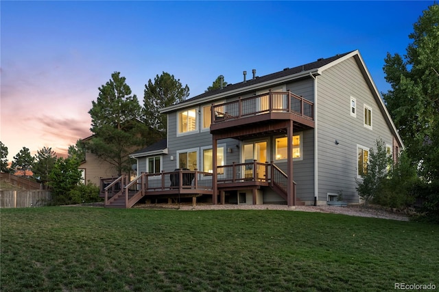 10039 Heatherwood Pl, Highlands Ranch, CO 80126 - back of property at dusk featuring a wooden deck, stairs, fence, and a lawn