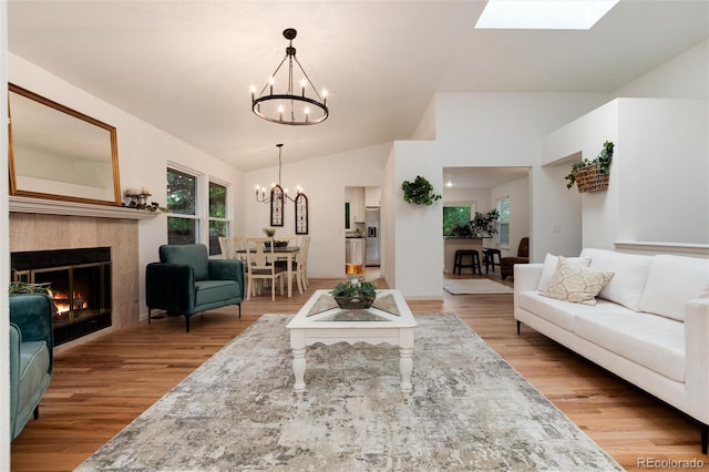 8543 Redstone St, Highlands Ranch, CO 80126 - living room featuring a chandelier, lofted ceiling, wood finished floors, and a tile fireplace