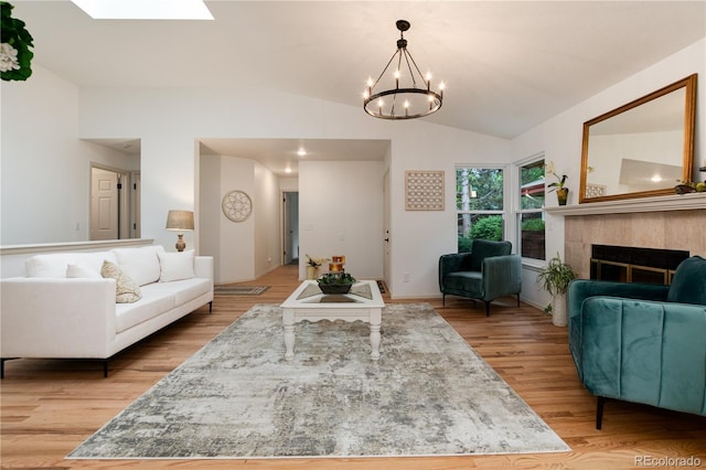 8543 Redstone St, Highlands Ranch, CO 80126 - living room with a chandelier, lofted ceiling, light wood-style floors, a fireplace, and a skylight