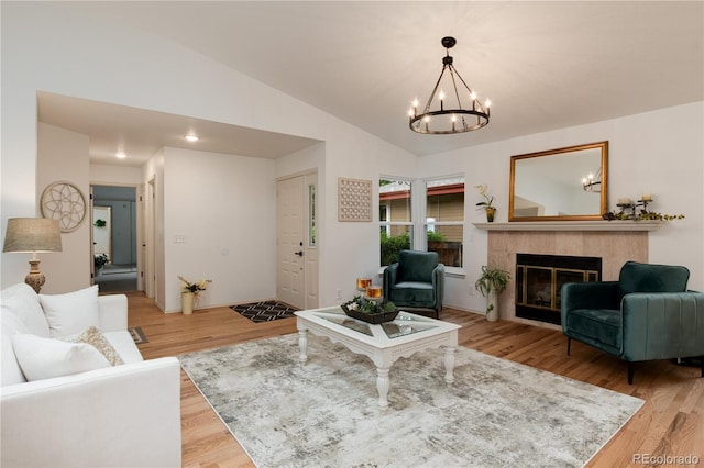 8543 Redstone St, Highlands Ranch, CO 80126 - living area with a chandelier, light wood-type flooring, a tiled fireplace, and lofted ceiling