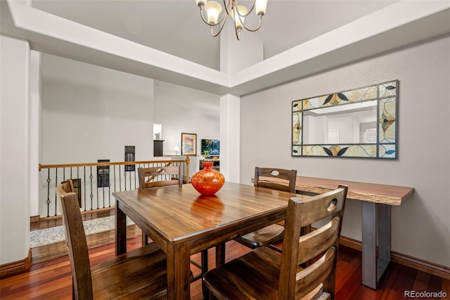 dining room with a high ceiling, dark hardwood / wood-style flooring, and an inviting chandelier