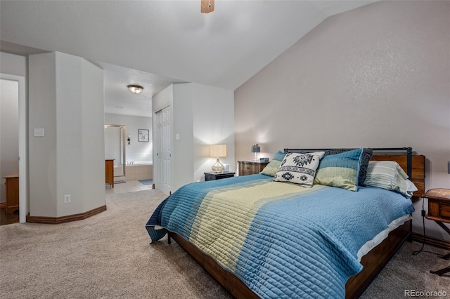 bedroom featuring ceiling fan, connected bathroom, a closet, vaulted ceiling, and carpet flooring