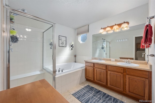 bathroom featuring tile patterned floors, vanity, and shower with separate bathtub