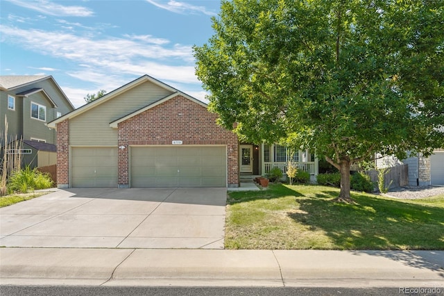 view of front facade with a garage, concrete driveway, brick siding, and a front yard