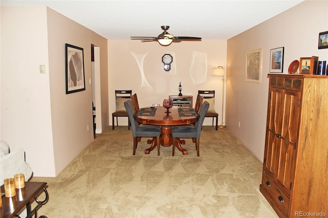 dining room featuring light carpet and a ceiling fan