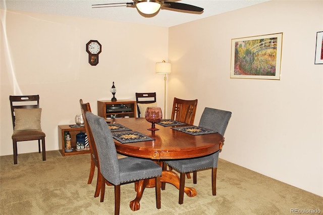 carpeted dining area with a ceiling fan