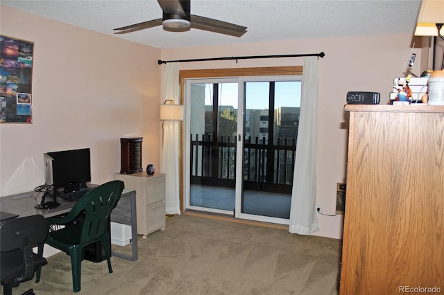 carpeted home office featuring ceiling fan and a textured ceiling