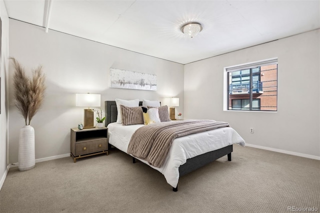 bedroom with baseboards and light colored carpet