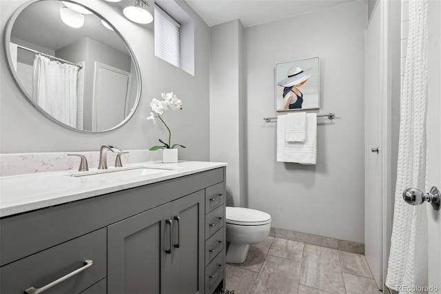 full bath featuring vanity, toilet, and baseboards