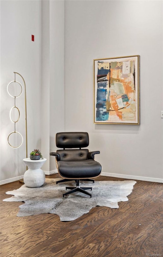 sitting room with baseboards and wood finished floors