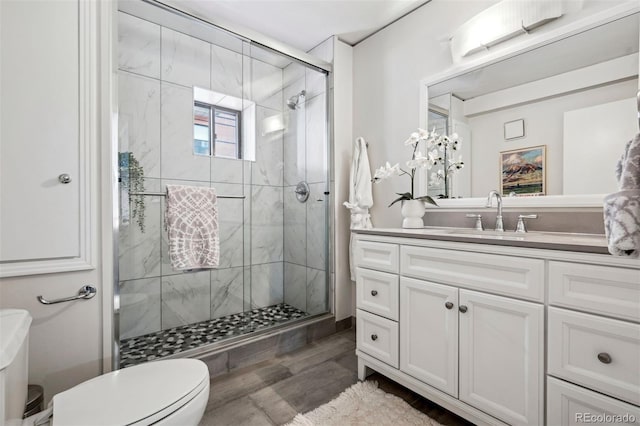 full bathroom with toilet, a stall shower, and vanity