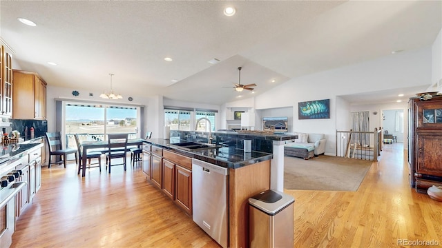 kitchen with a sink, stainless steel dishwasher, open floor plan, brown cabinetry, and vaulted ceiling