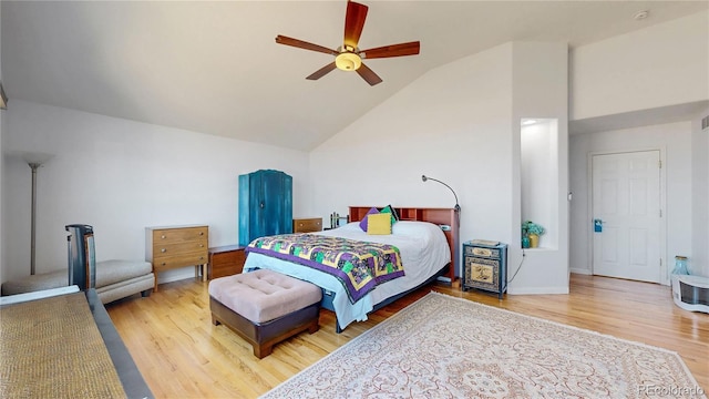 bedroom featuring a ceiling fan, wood finished floors, baseboards, and high vaulted ceiling