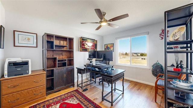 office area featuring light wood-type flooring, baseboards, and ceiling fan