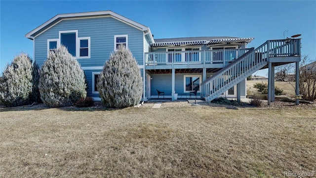 rear view of house featuring stairway, a lawn, and a deck