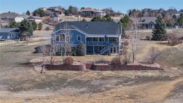 back of property with a residential view, stairs, a deck, and fence