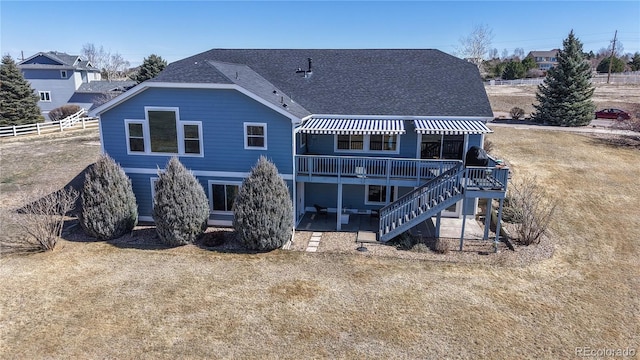 back of property with roof with shingles, a deck, stairs, and fence