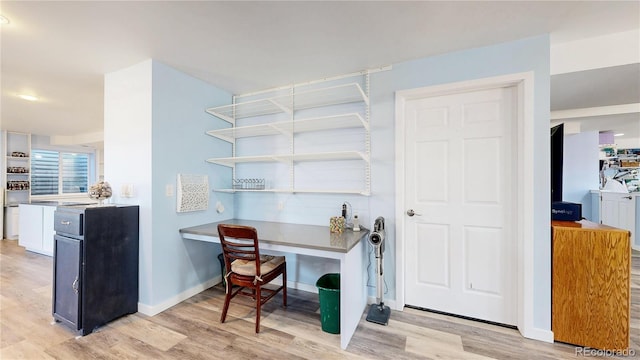 office with baseboards and light wood-style flooring