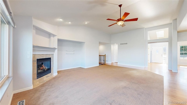 14701 Yosemite St, Brighton, CO 80602 - unfurnished living room with ceiling fan, a tiled fireplace, high vaulted ceiling, and light carpet