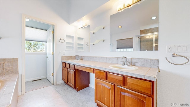 14701 Yosemite St, Brighton, CO 80602 - full bath featuring double vanity, a stall shower, a bathtub, tile patterned floors, and baseboards