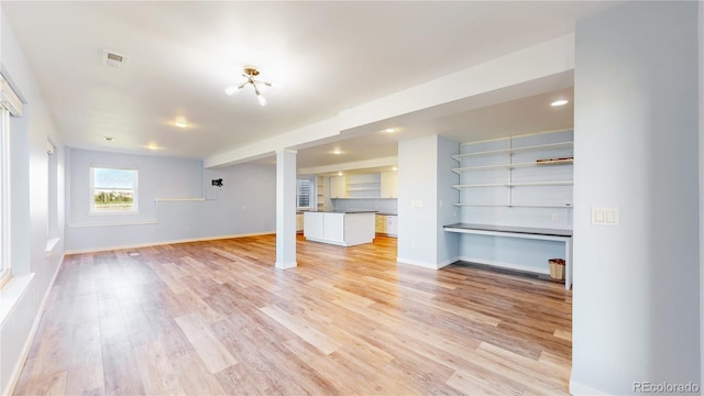 14701 Yosemite St, Brighton, CO 80602 - unfurnished living room with ornate columns, light wood-style floors, and baseboards